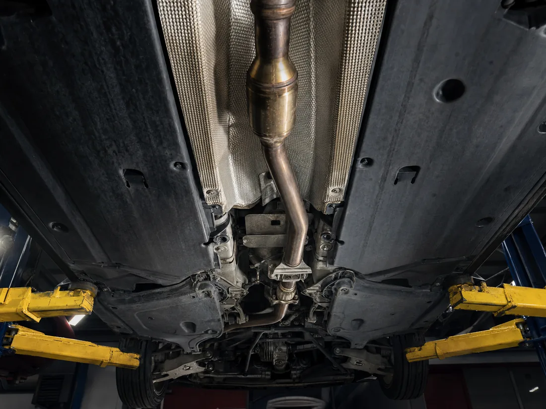 The exhaust and catalytic converter under a car on a lift