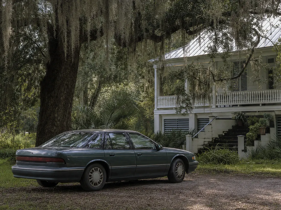Older sedan parked under a live oak draped with Spanish moss beside a raised Gulf Coast cottage in Mobile Alabama - selling a car in Mobile