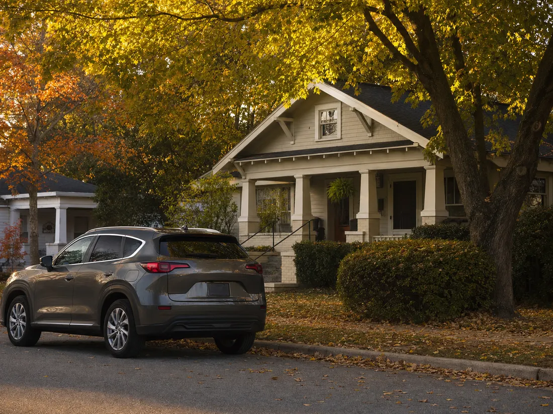 Compact SUV parked outside a craftsman cottage on a leafy student-neighborhood street in Tuscaloosa Alabama - selling a car in Tuscaloosa