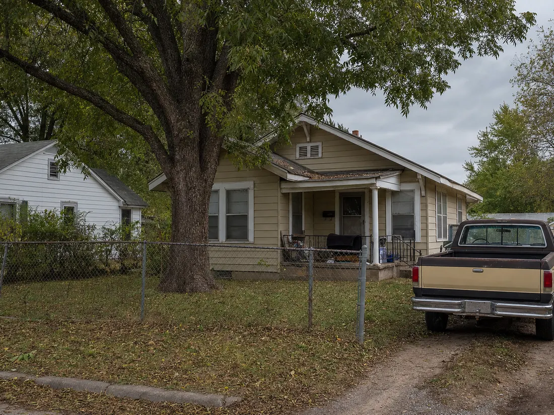 Older pickup beside a modest frame bungalow in Fort Smith Arkansas with a chain-link fence and mature pecan tree - selling a car in Fort Smith