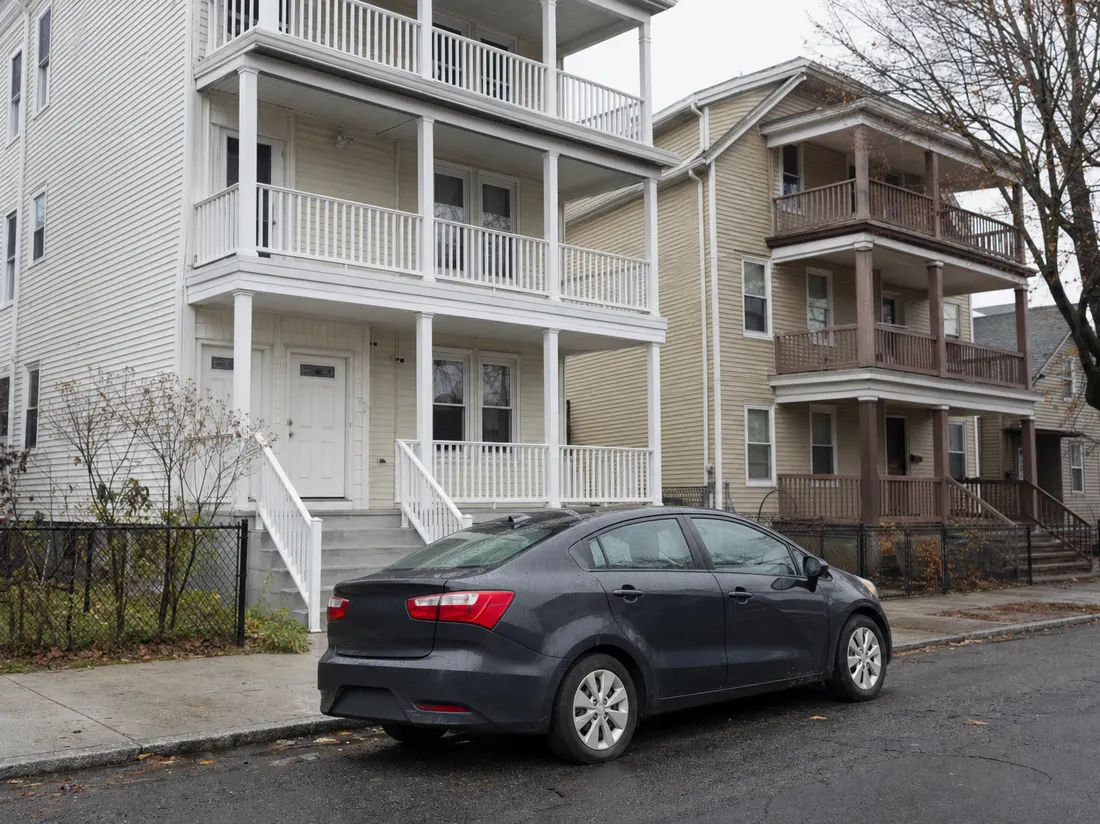Sedan parked on the street outside a triple-decker home in Bridgeport Connecticut with small front porches - selling a car in Bridgeport