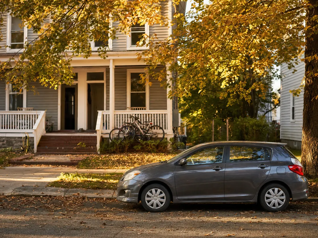 Compact hatchback outside a student duplex on a leafy street in Newark Delaware, bikes on the porch - selling a car in Newark