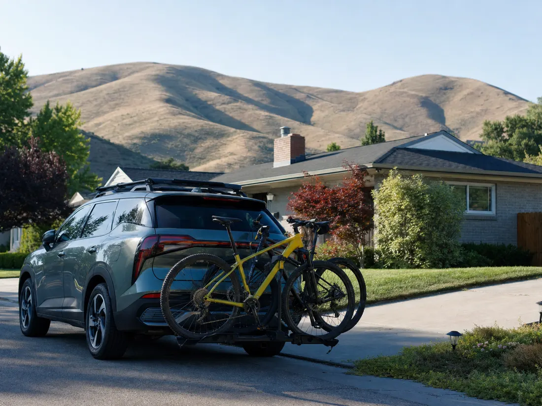 Crossover with a bike rack in the driveway of a bungalow in Boise Idaho with the brown foothills rising behind the rooftops - selling a car in Boise