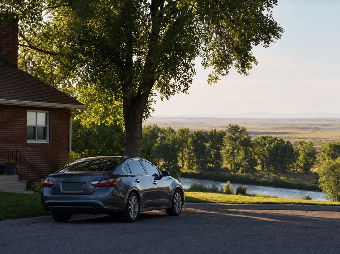 Sedan parked beside a brick home in Idaho Falls Idaho with cottonwoods along the river and the flat Snake River plain stretching out - selling a car in Idaho Falls
