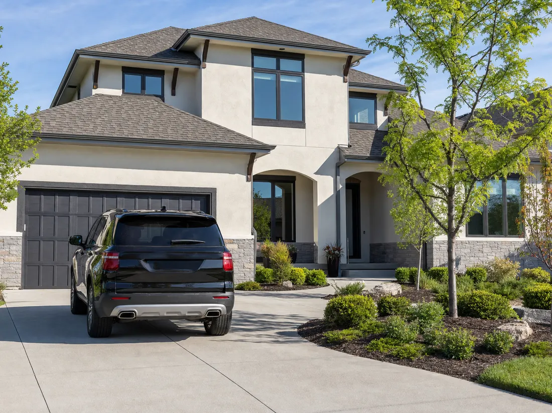 Clean SUV in the driveway of a two-story suburban home in Overland Park Kansas with landscaped beds and young maples - selling a car in Overland Park