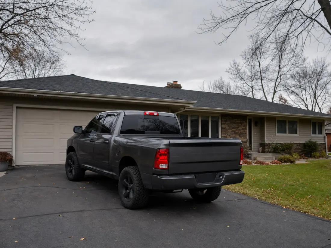 Pickup in the driveway of a rambler home in St. Cloud Minnesota with granite-gray skies and bare oaks - selling a car in St Cloud