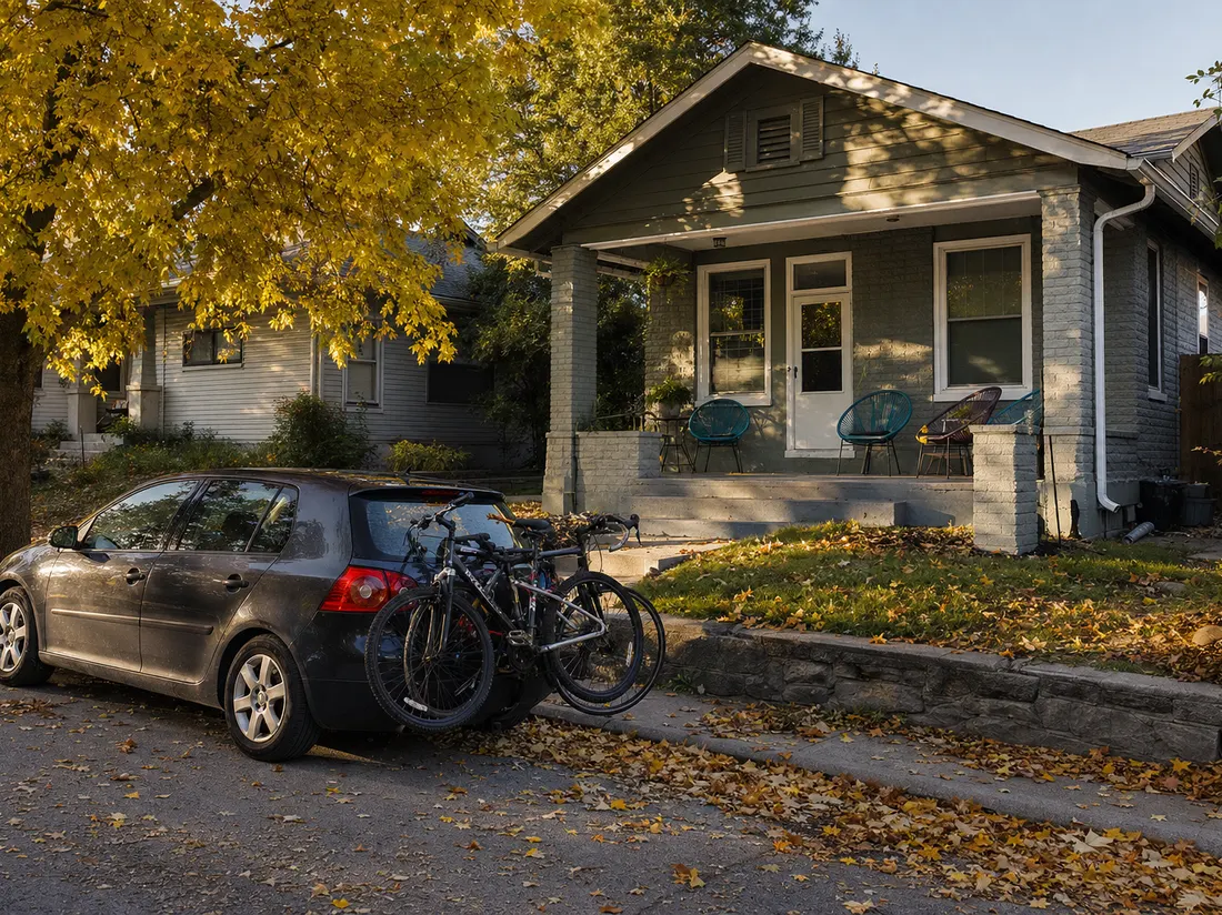 Hatchback with a bike rack outside a student rental bungalow on a leafy Columbia Missouri street, porch chairs and fall color - selling a car in Columbia