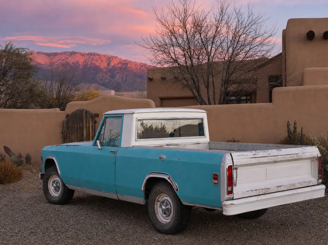 Older pickup at an Albuquerque adobe home with the Sandia mountains pink at sunset - selling a car in Albuquerque