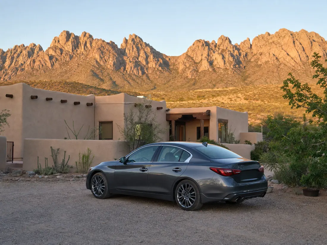 Sedan in the gravel yard of an adobe home in Las Cruces New Mexico with the jagged Organ Mountains behind - selling a car in Las Cruces