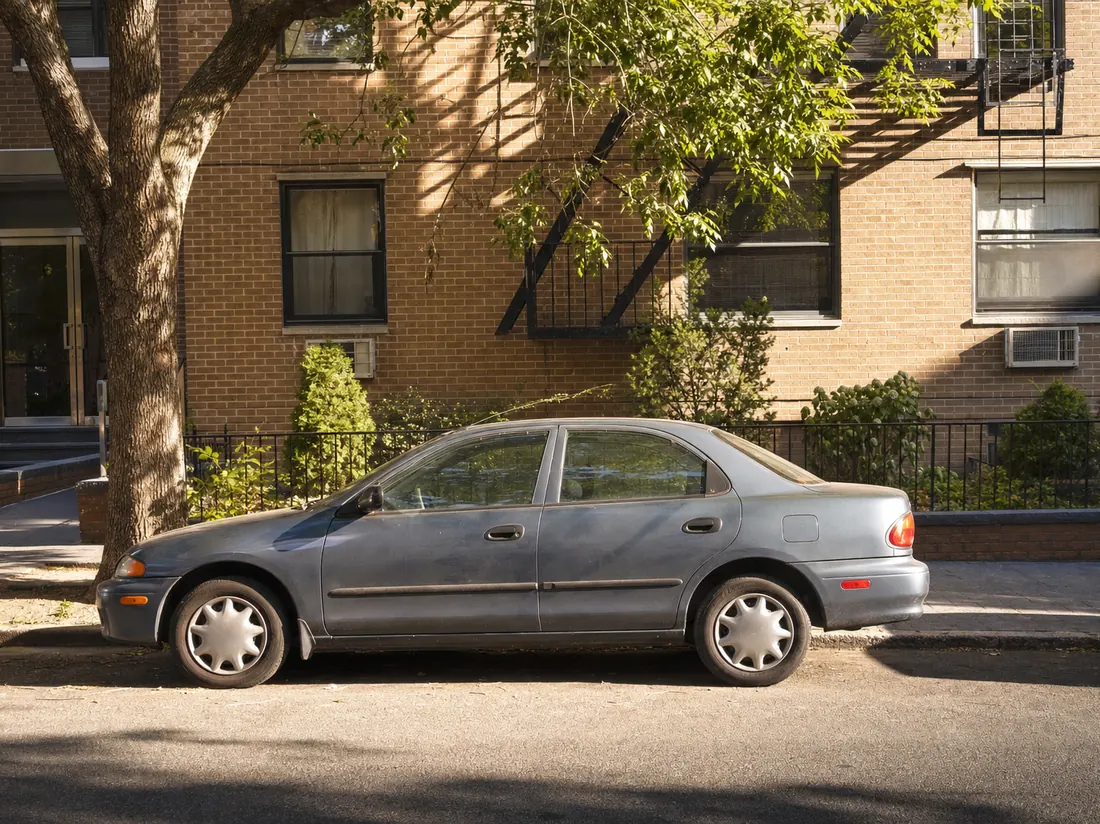 Car parallel-parked on a residential Queens street - selling a car in NYC without a garage