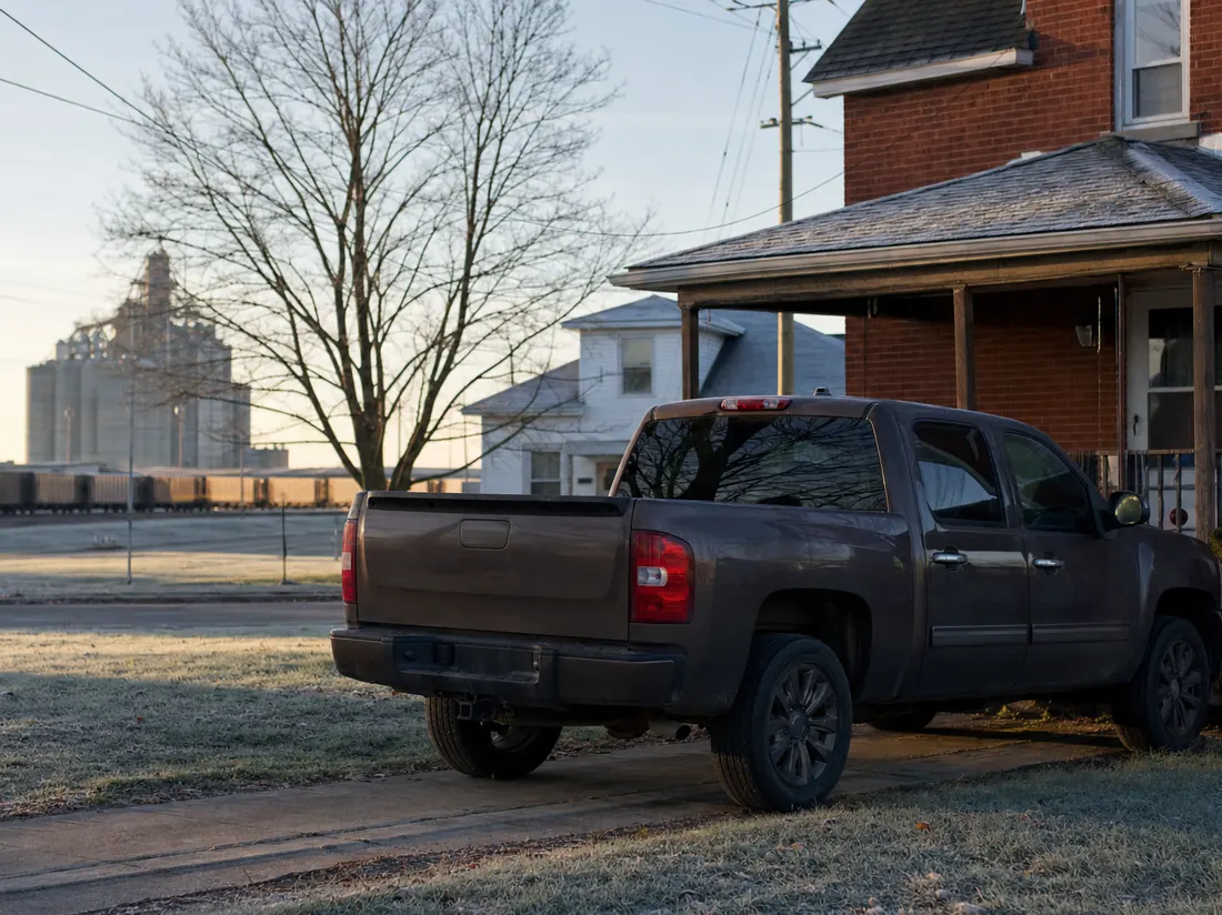 Pickup beside a Toledo brick home with a grain elevator faint in the distance - selling a car in Toledo
