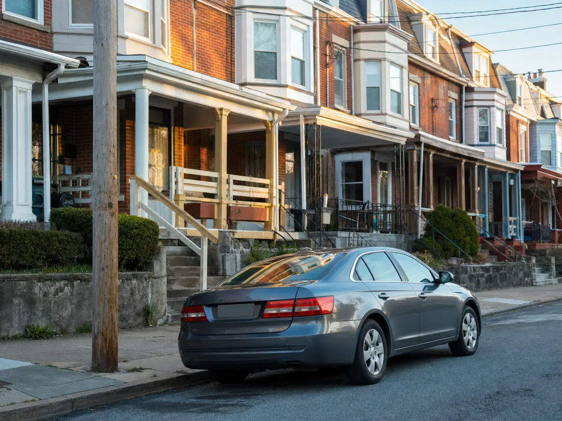 Sedan on a sloped Allentown block of brick rowhomes with painted porches - selling a car in Allentown