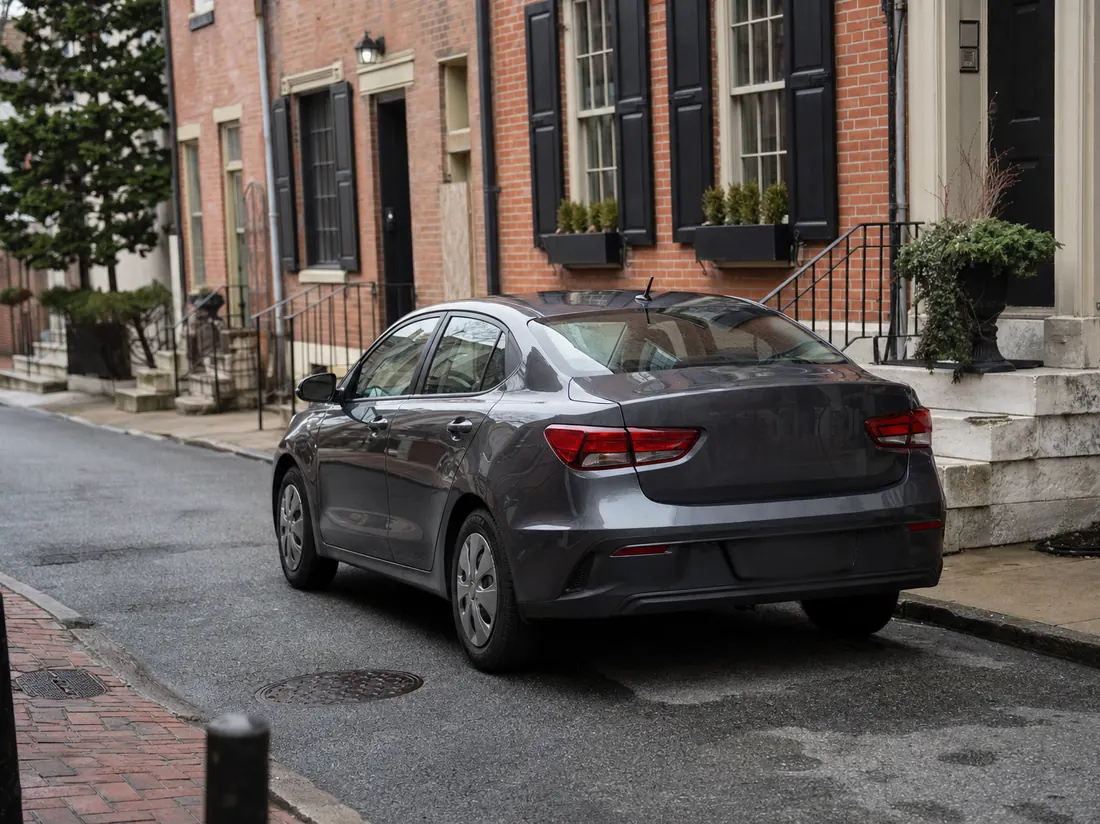 Compact sedan on a narrow Philadelphia rowhouse street with brick facades and marble steps - selling a car in Philadelphia