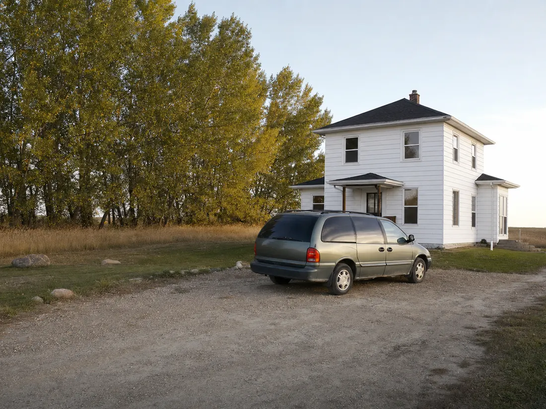 Older minivan by a prairie foursquare home in Aberdeen South Dakota with a windbreak of cottonwoods - selling a car in Aberdeen