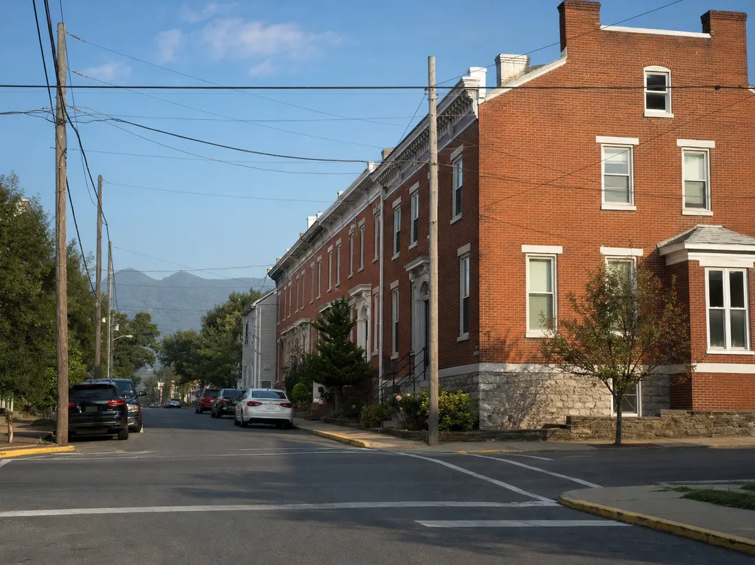 Crossover by a brick rowhome in Martinsburg West Virginia with a ridge of the Blue Ridge hazy at the street's end - selling a car in Martinsburg