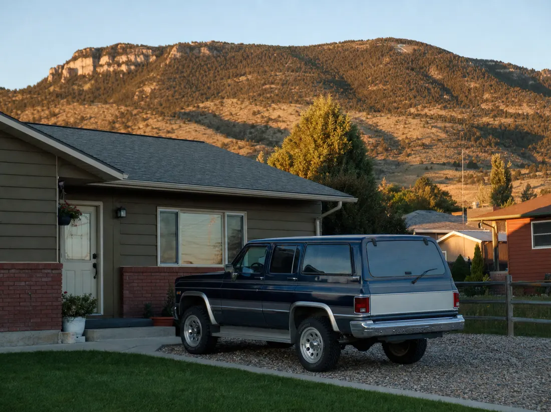 Older SUV beside a ranch home in Casper Wyoming with Casper Mountain rising behind the neighborhood - selling a car in Casper