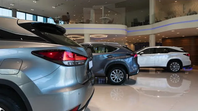 The opening frame of the Delaware DMV's own walkthrough of form MV212: three sport-utility vehicles standing on a polished showroom floor under a curved first-floor balcony.